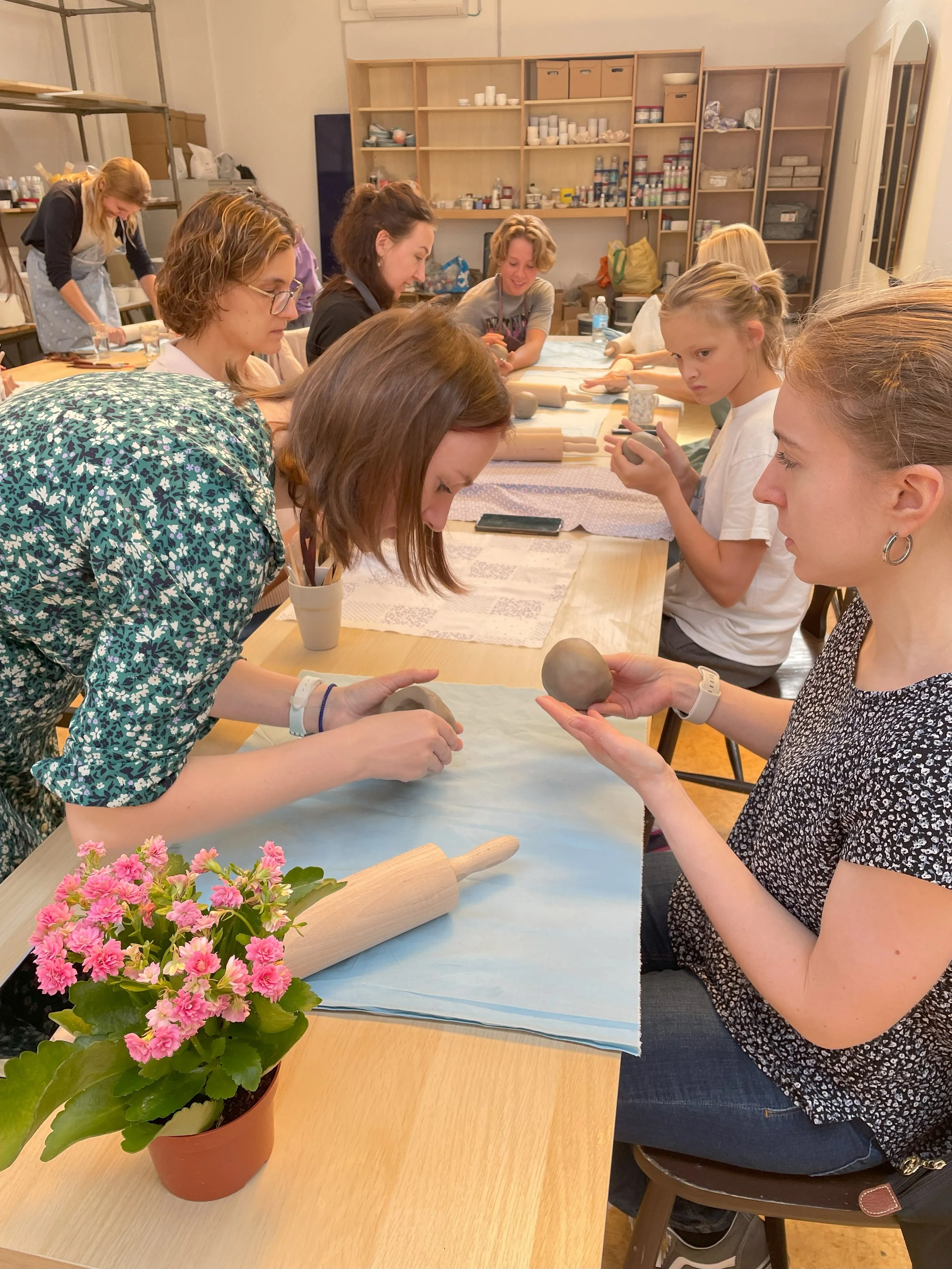 A clay workshop at the studio, adults and children at the same table
